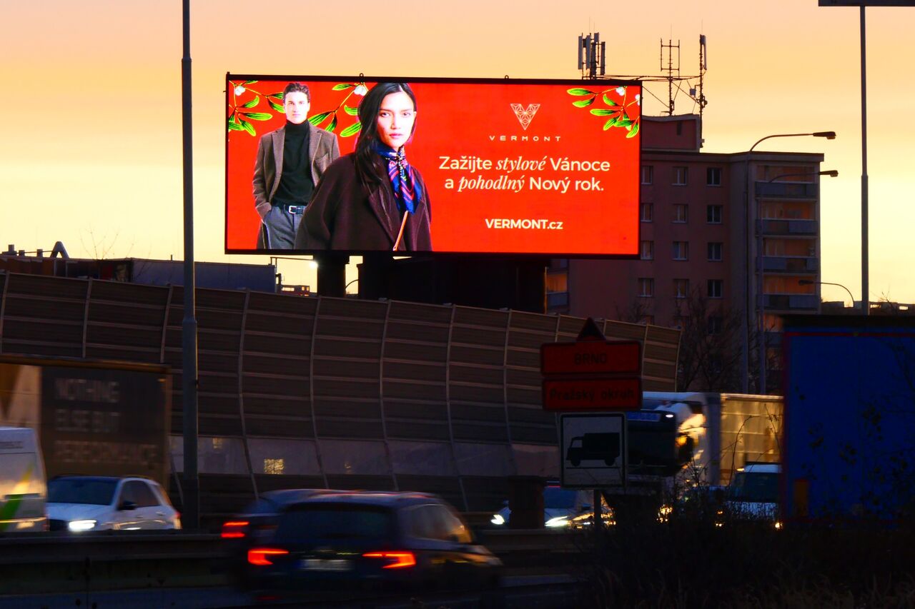 Vánoční kampaň Vermont na velkoplošné LED obrazovce nad silnicí za soumraku